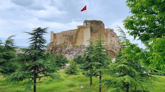 Harput fortress with the Turkish flag, in the spring in Eastern Anatolia, Elazig, Turkey. Harput Castle or Harberd, also known as Sut Kalesi. Ancient city. 4К