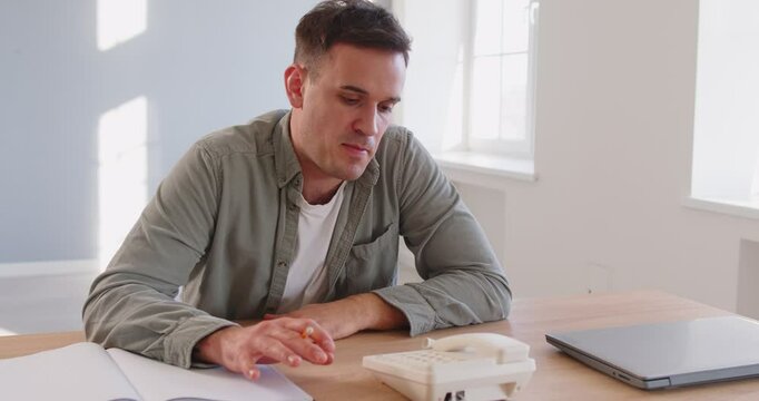Man at office desk in worry and frustration, thinking pondering, anxious unhappy about phone call, suffering from problems, long waiting for call, unable to change, make decision, less confident 