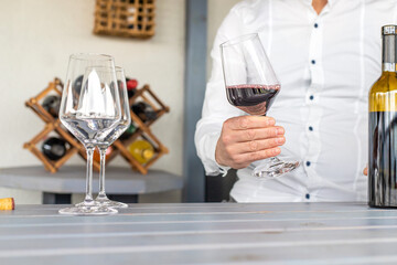 Glass of red wine in hands. Selective focus.