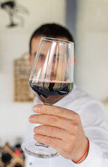 Glass of red wine in hands. Selective focus.