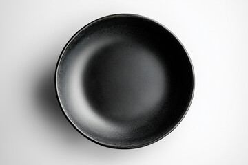 A close-up, top-down view of a matte black bowl, highlighting its smooth, simple design