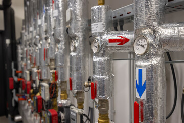 Heating system pipes and valves regulating temperature with manometer showing hot water temperature