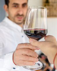 Glass of red wine in hands. Selective focus.