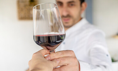 Glass of red wine in hands. Selective focus.