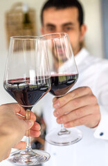 Glass of red wine in hands. Selective focus.