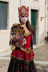 Venice, Italy - People dressed in carnival masks are photographed by tourists in the scenery of the ancient Venetian palaces