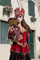 Obraz premium Venice, Italy - People dressed in carnival masks are photographed by tourists in the scenery of the ancient Venetian palaces