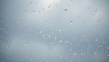 rain drops on a window with a cloudy sky in the background