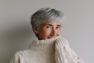 portrait of joyful elderly woman unwrapping handmade sweater gifted from friend