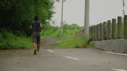 Nature, fitness and asian man in the park for running challenge, wellness and healthy outdoor exercise.
