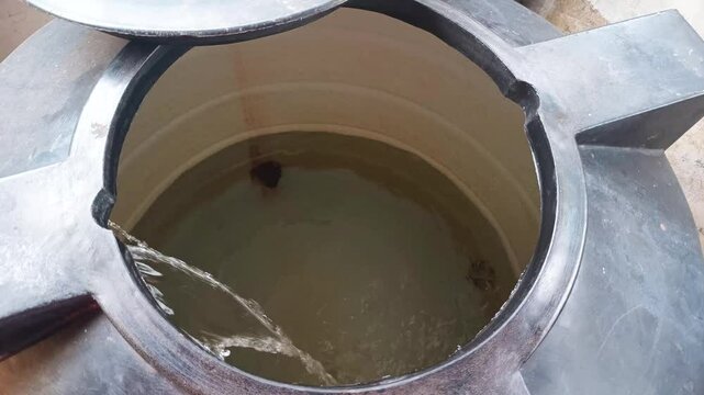 Water steadily filling up a water tank in an outdoor setting
