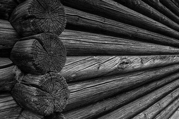 Perspective view of the wall of a log house. Log wall of an old house, close-up. Perspective view of parallel logs, macro.