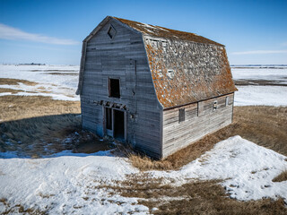 Large, old barn sits in a snowy field