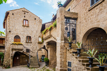 Stone houses with balconies, arches, and external staircases create a picturesque scene in the heart of Viterbo, Latium, Italy, showcasing the city's rich history and architectural heritage