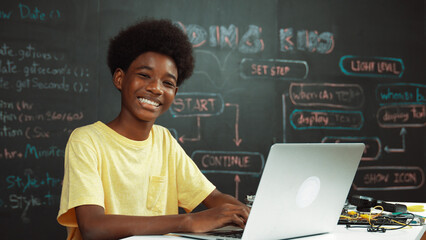 African highschool student using laptop programing system or coding prompt and smile to camera....