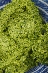 A close-up, top-down shot reveals the textured surface of vibrant green wild garlic (Allium...