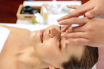 Closeup woman enjoying relaxing anti-stress head massage and pampering facial beauty skin...