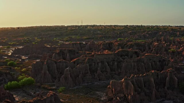 Aerial view of rugged cliffs in Chakwal, Pakistan, with green patches dotting the landscape