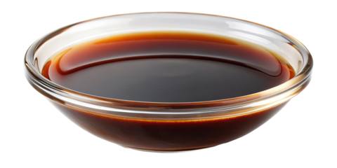 A closeup of a transparent glass bowl filled with dark soy sauce