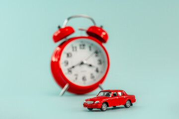 Alarm clocks model toy car on a blue isolated background, it's time to buy a car, repair time