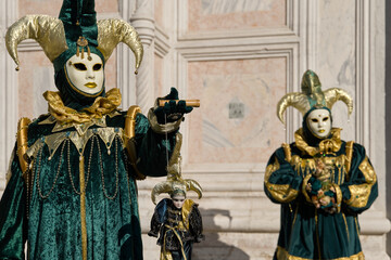 Venice, Italy - People dressed in carnival masks are photographed by tourists in the scenery of the ancient Venetian palaces