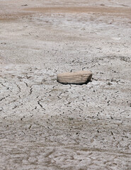 Car tire thrown into a drained lake. Rubber left in nature.