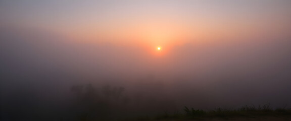 Fototapeta premium sun is setting in the foggy sky