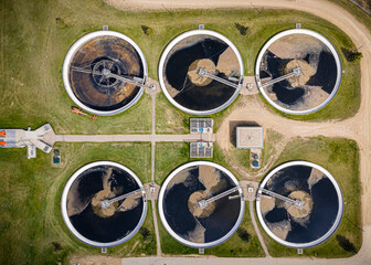 Series of large water tanks are shown in a grassy area