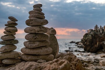 Stone Cairns Beach Sunset - Two stone cairns stacked on a beach at sunset.