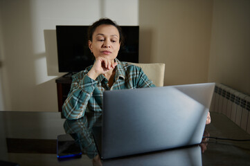 Woman Using a Laptop at Home Reflective and Focused