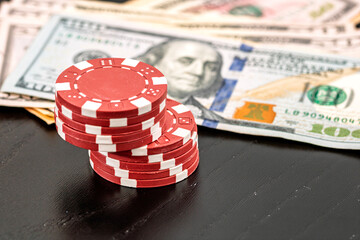 Stacks of poker chips with money on black background