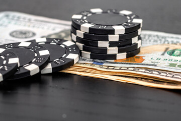 Stacks of poker chips with money on black background