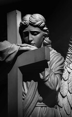 Death. Sad angel as symbol of pain, fear and end of life. Ancient stone statue. Black and white...