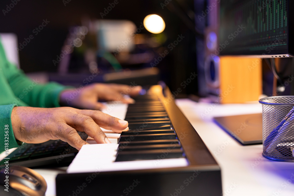 Poster songwriter performing a song on electronic piano keyboard, editing the audio files in post productio