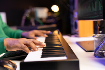 Songwriter performing a song on electronic piano keyboard, editing the audio files in post...