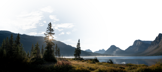 Panorama of calm lake, mountains and trees looking at the sun with a partially transparent sky
