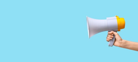 Hand holding megaphone on light blue background with space for text