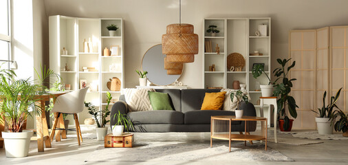 Interior of stylish living room with sofa, workplace, table and shelving units