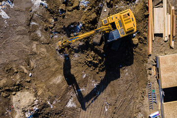 Large yellow excavator is digging in the dirt © Scott Prokop