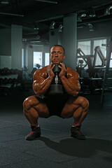 dedicated athlete executes a squat while holding a dumbbell showcasing impressive strength and...