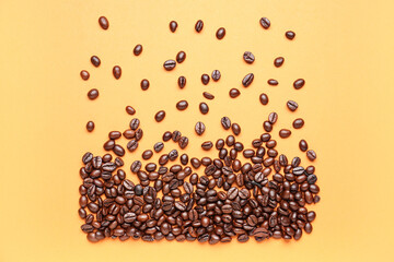 Scattered coffee beans on orange background