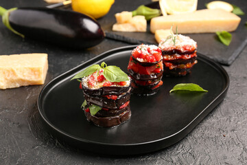 Tray with tasty baked Eggplant Parmesan on dark background