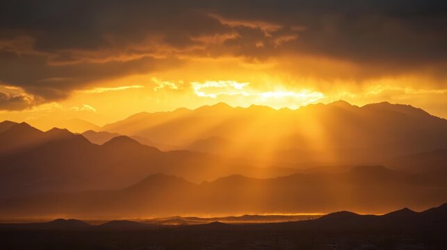 Golden sunset over the mountains casts sunbeams through the clouds. - Powered by Adobe