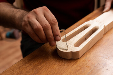The master grinds the surface of the neck with a piece of glass