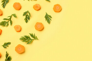 Slices of fresh carrots on yellow background