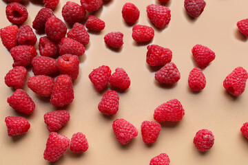 Many fresh raspberries on beige background