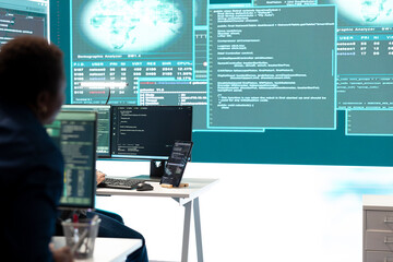 Cyber defense specialist examining information on a big screen in governmental center, focusing on cyber security operations and digital threats. Hacker ensures protection against cybercriminals.