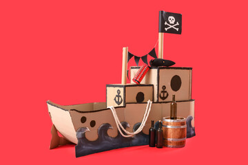 Pirate cardboard ship with explosive and bottles on red background