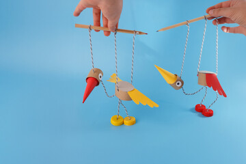 DIY bird marionettes made from recycled materials held by hands with pencils, ideal for eco...