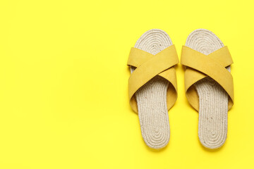 Stylish yellow sandals on color background